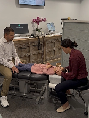 Dr. Ivan Sanchez and Dr. Sabrina Sanchez adjusting child